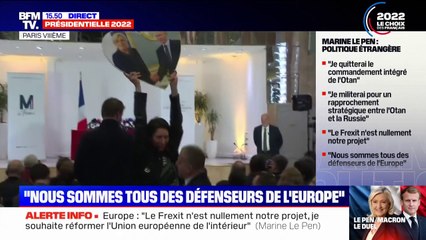 Une militante brandissant une photo de Marine Le Pen et de Vladimir Poutine exfiltrée de la conférence de presse