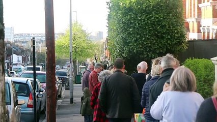 Dozens of people waiting for hot cross buns in Brighton
