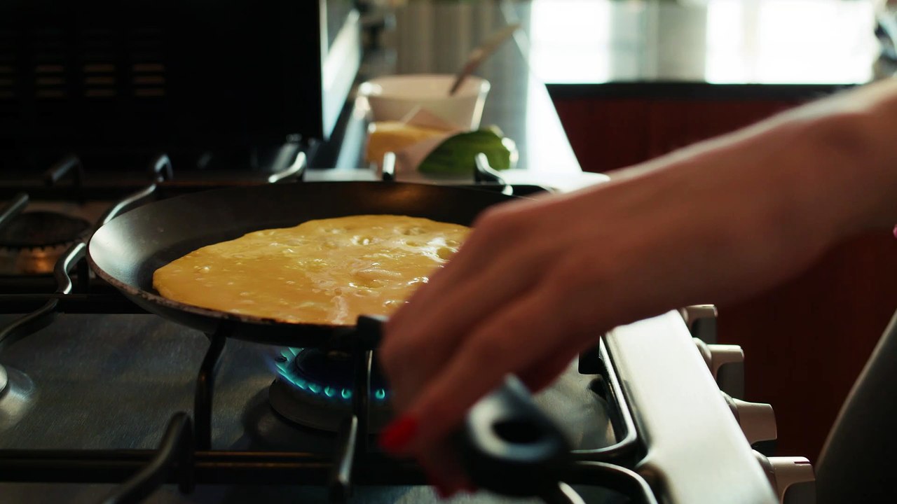 mixkit-woman-flipping-her-egg-omelet-42910