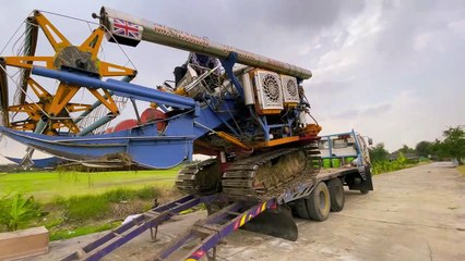 Loading a rice harvester machine in Thailand
