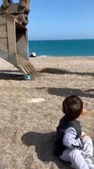 Sahilde oynayan minik çocuğun kum kovasını iş makinesi doldurdu