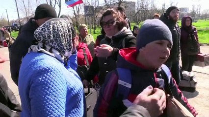 Mariupol residents queue for a small convoy of evacuation buses to leave the city