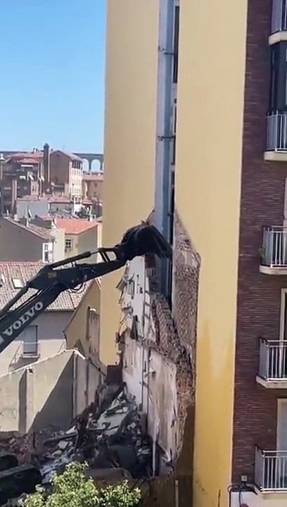 Le conducteur d'une pelleteuse fait une grosse boulette en démolissant la façade d'un immeuble