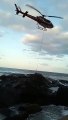 Homem ilhado em mar agitado é pendurado em helicóptero para resgate em Florianópolis