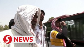 Sprinklers and scarves help Indians seeking relief from heatwave