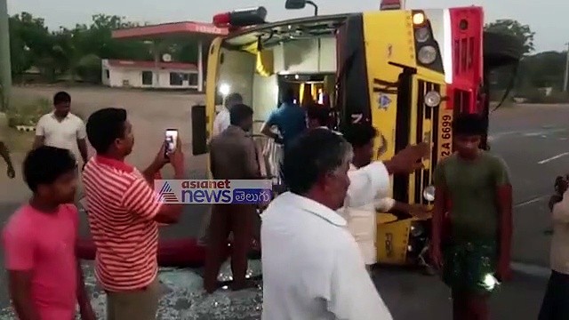 అదుపు తప్పి బోల్తా: బస్సు కింద ఇరుక్కున్న డ్రైవర్ (వీడియో)