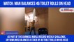 Man balances toilet rolls