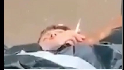 جثه تدخن سيجاره بين كومة جثث فى أكياس,الشهيد الحى