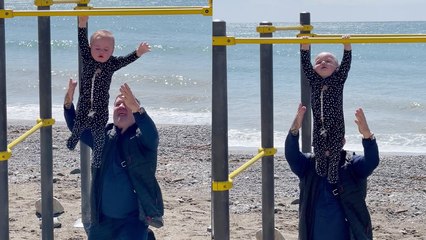 'This little fitness freak can hang from a pull-up bar on his own! '
