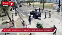 Otomobilin altında kalan motosikletliyi aracı havaya kaldırarak kurtardılar