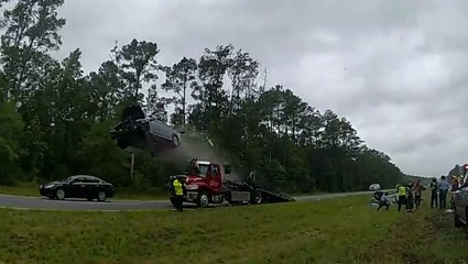 Shocking moment car flies through the air after launching off back of stationary tow truck