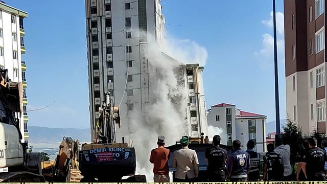 Depremde hasar gören bina yıkım esnasında sağlam binanın üzerine devrildi