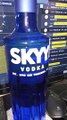 presentando una botella de vodka skyy y algunas botanas en la oficina preparando todo para la fiesta epica