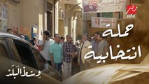 وسط البلد | الحلقة 78 | كامل الجارحي يقوم بجولة انتخابية ومنافسه ينشر صوره في الحارة