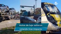 Tren parte a la mitad camión con autos de lujo