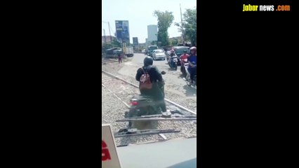 Seorang wanita panik motornya mati dan nyangkut di perlintasan rel kereta api