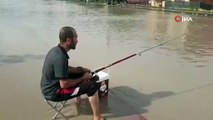 Göle dönen caddeye olta attı, balık tutmaya çalıştı