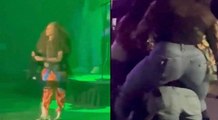 Erykah Badu sings while two women fight during her performance