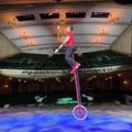 Professional Juggler Juggles Multiple Clubs While Balancing on High Unicycle