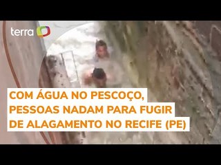Com água no pescoço, pessoas nadam para fugir de alagamento no Recife (PE)