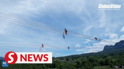 "Spider men" work 200 meters above river