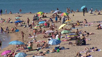 Turistas y barceloneses acuden a la playa para soportar la ola de calor