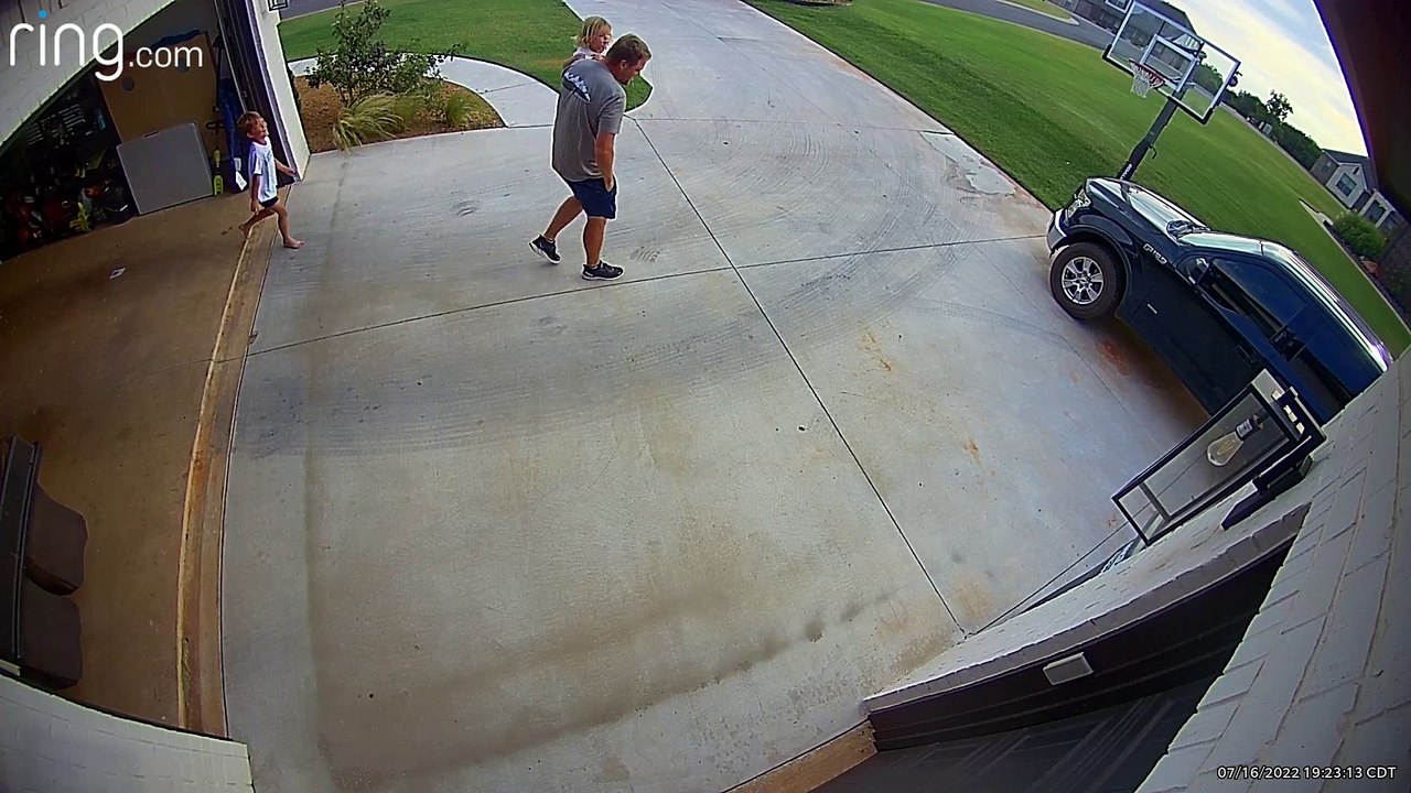 Little Girl Hangs on to Opening Garage Door