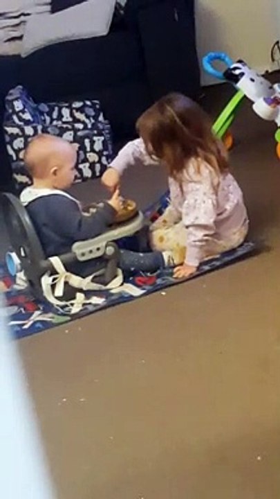 Big Sister Helping Her Little Brother Finish His Dinner