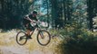 Guy Speeds Down a Narrow Forest Trail on Mountain Bike