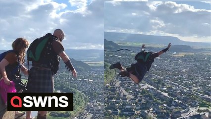 Thrill-seekers dressed in kilts base jump from top of William Wallace Monument in Stirling