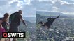 Thrill-seekers dressed in kilts base jump from top of William Wallace Monument in Stirling