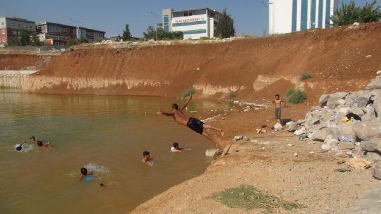 ÇOCUKLAR, İNŞAAT TEMELİNİ DOLDURAN KİRLİ SUDA YÜZÜYOR