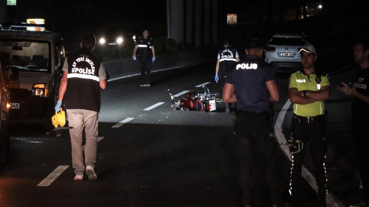 Devrilen motosikletten yola savrulan iki kişinin üzerinden araba geçti