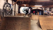 BMX rider jumps off top of half pipe at skatepark and faceplants