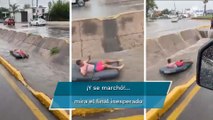 Joven aprovecha inundación para surfear en un canal