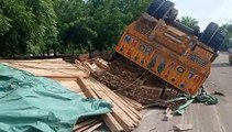 Trailor overturned : गोलाई में लकडि़यों से भरा ट्रेलर पलटा
