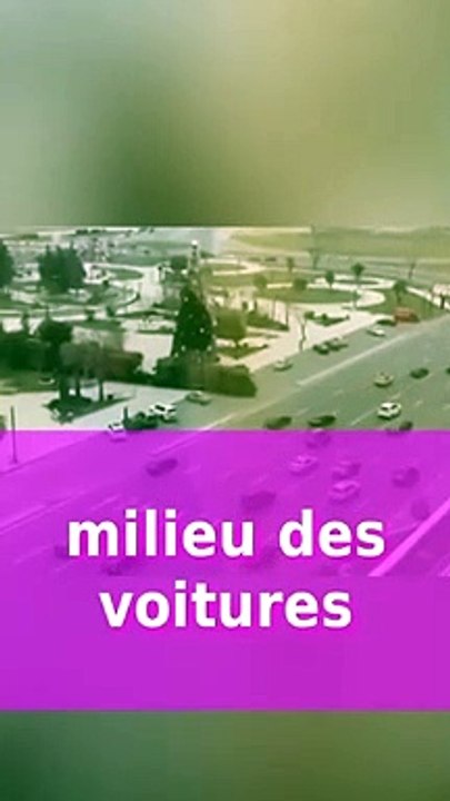 Un train passe au milieu des voitures