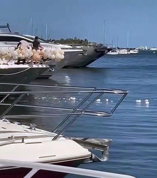 Ils jettent les ballons de baudruche dans l'eau après une fête sur un yatch
