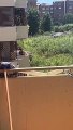 Une femme tente d'éteindre un feu depuis son balcon