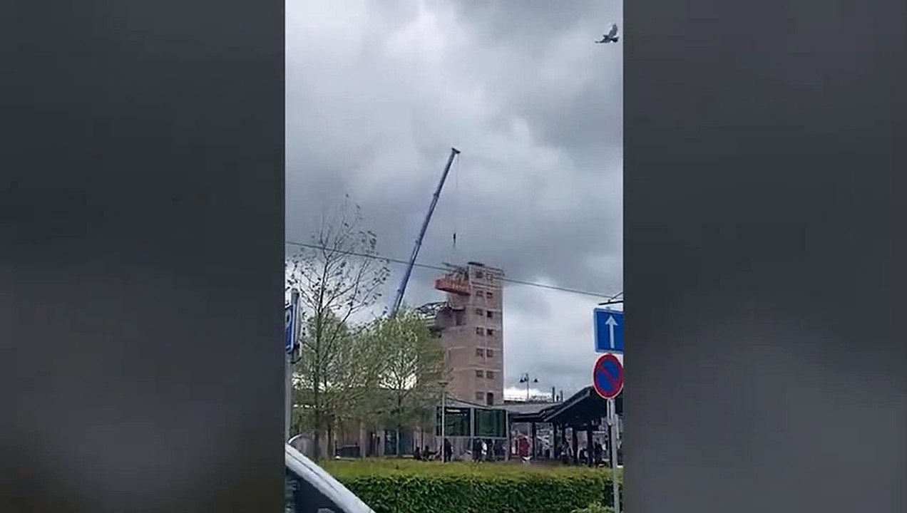 Une pelleteuse dans un conteneur perché en hauteur avec une grue