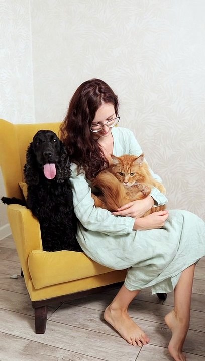 A Woman Holding a Cat While Sitting Beside a Dog · Free Stock Video