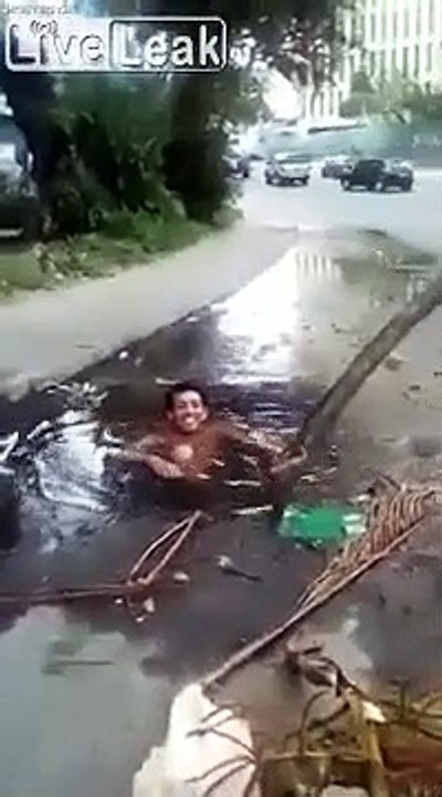 Jacuzzi de fortune, il se baigne dans un trou sur la route pendant les inondations