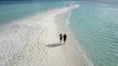 Couple Walking on a Beach Filmed with a Drone