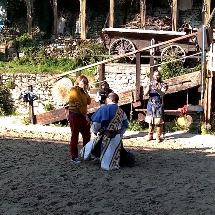 Il la demande en mariage en costume médiéval, sur son cheval blanc