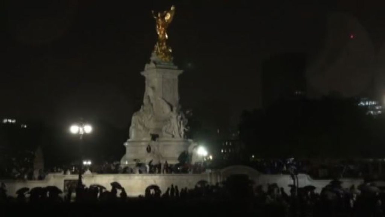 Londra, folla di notte con la pioggia al Queen Victoria Memorial