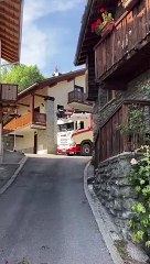 Camión de madera pasa por una calle muy estrecha