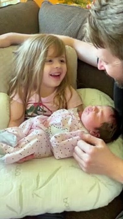 Little Girl Preciously Holds Her Newborn Baby Sister