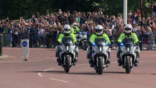 King waves to crowds as he arrives at Palace
