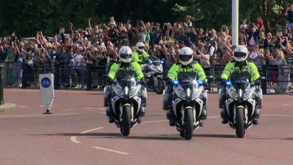 King waves to crowds as he arrives at Palace