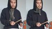 Cat adorably goes into owner's hoody while he plays drums